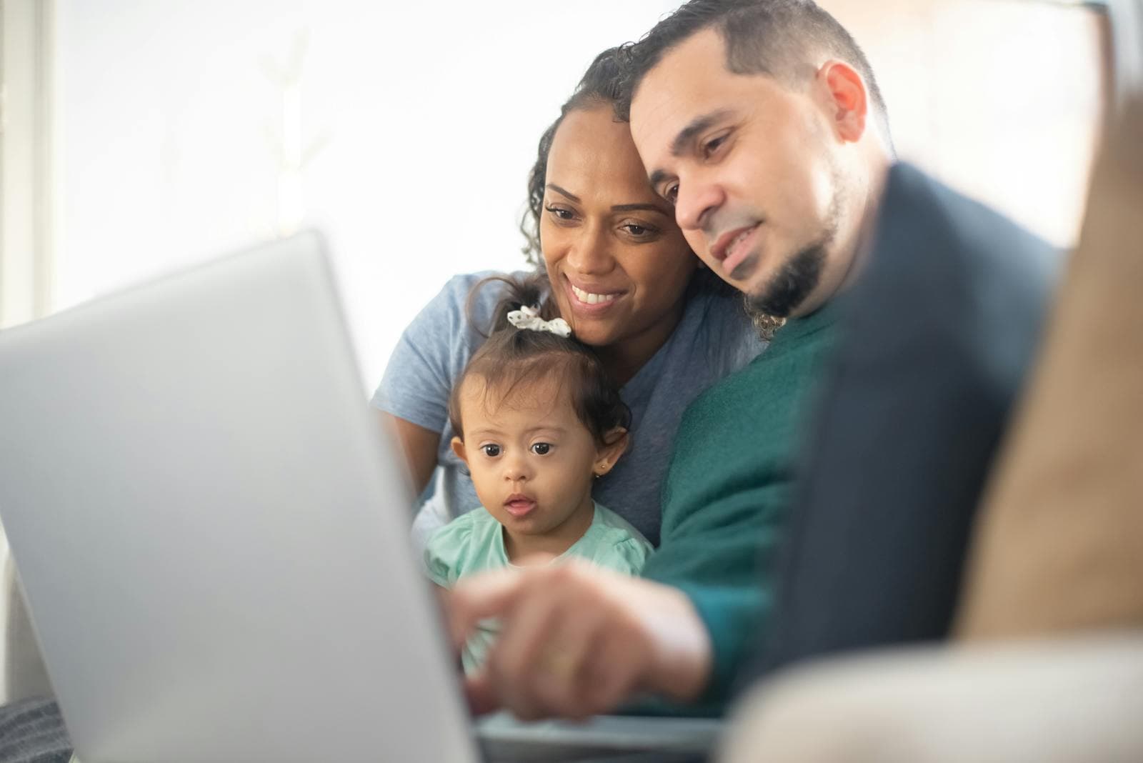 Family looking together at a laptop at home.